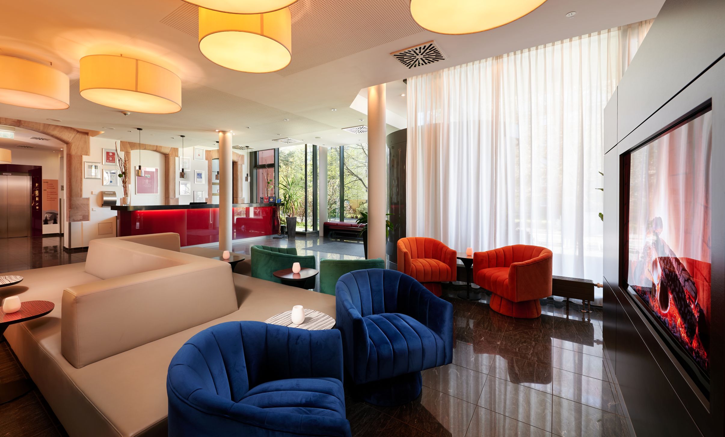 Moderne Hotellobby ohne Personen mit blauen Sesseln und roten Stuehlen
